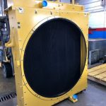 Rebuilt CAT 988 wheel loader radiator with yellow shroud at St. Louis repair facility