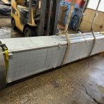 Forklift lifting large industrial heat exchanger for repair at St. Louis radiator service shop