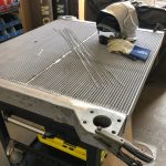 Liebherr radiator core on workbench with welding gear at St. Louis cooling system repair facility